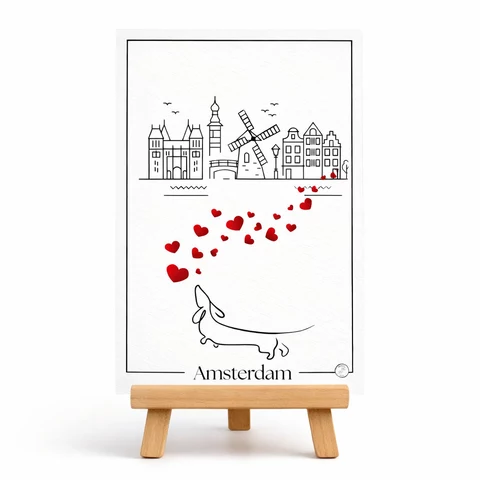 Carte verticale avec cadre noir fin, skyline stylisée en noir, moulin à vent, oiseaux schématiques, arc de petits cœurs rouges et mot Amsterdam en bas.